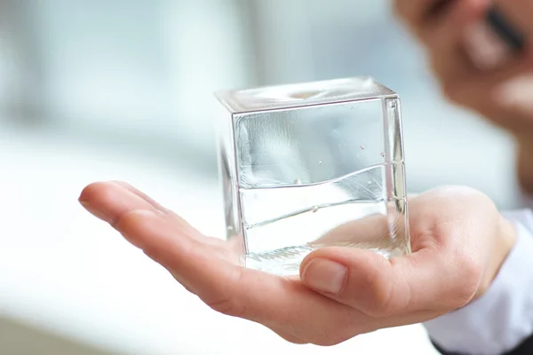 Glass cube in  hand — Stock Photo, Image