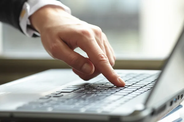 Vrouwelijke hand schrijven op laptot — Stockfoto