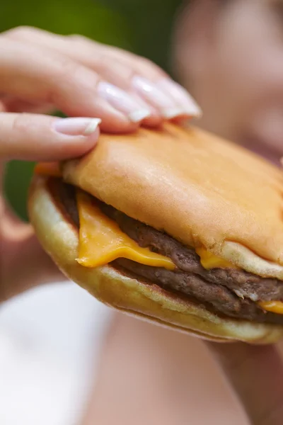 Žena jíst hamburger — Stock fotografie