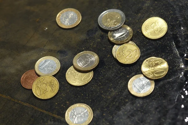 Coins under clear water — Stock Photo, Image