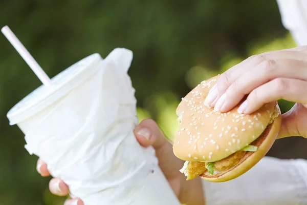 Mujer comiendo hamburguesa y cóctel —  Fotos de Stock