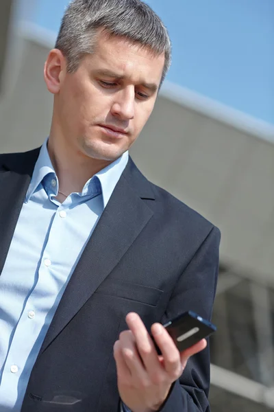 Homme d'affaires avec téléphone à l'extérieur — Photo