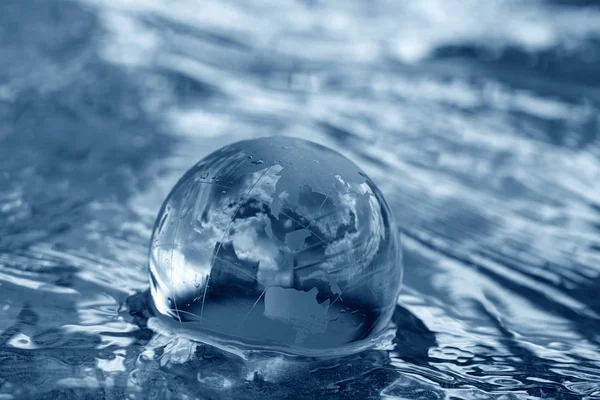 Glass globe in water — Stock Photo, Image