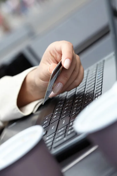 Mulher segurando cartão de crédito no laptop — Fotografia de Stock