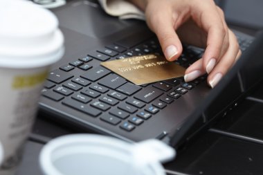 Bilgisayarında kredi kartı olan kadın.