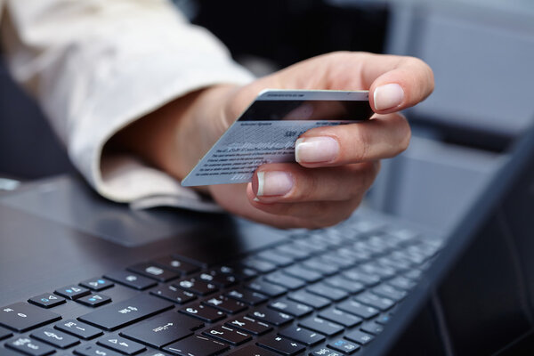 Woman with credit card on laptop