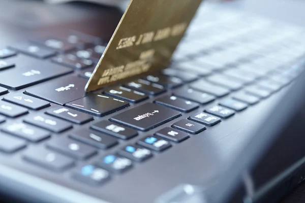 Woman holding credit card on laptop — Stock Photo, Image