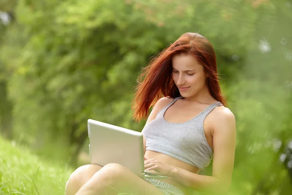 Donna con computer portatile nel parco — Foto Stock