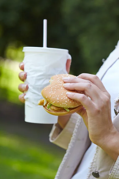 Žena jíst hamburger — Stock fotografie