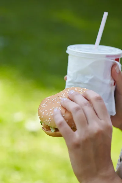 Mujer comiendo hamburguesa y cóctel —  Fotos de Stock