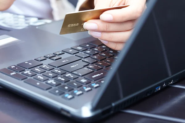 Woman holding credit card on laptop Stock Photo