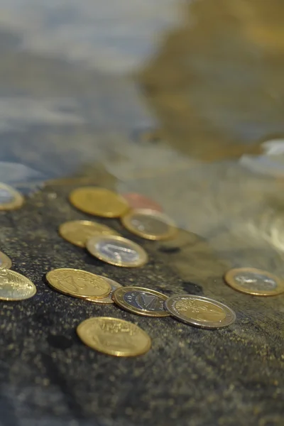 Монеты под чистой водой — стоковое фото