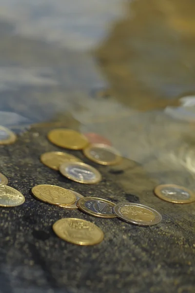 Coins under clear water — Stock Photo, Image