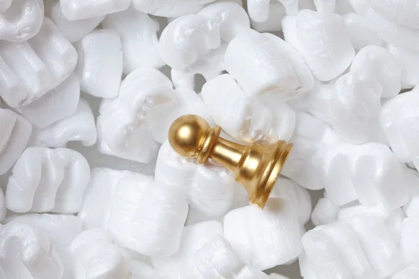 Golden pawn over white polystyrene — Stock Photo, Image