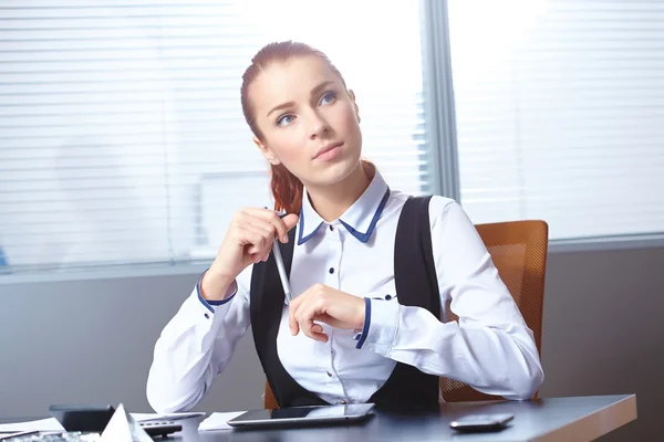 Junge Geschäftsfrau sitzt am Arbeitsplatz — Stockfoto