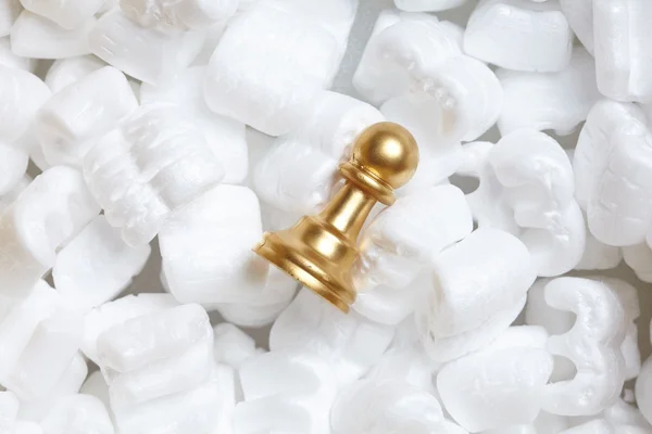 Golden pawn over white polystyrene — Stock Photo, Image