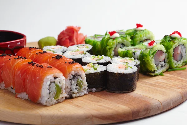 Rollos de sushi sobre tabla de madera — Foto de Stock