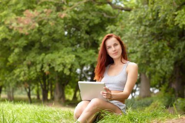 Parkta dizüstü bilgisayarı olan kadın.
