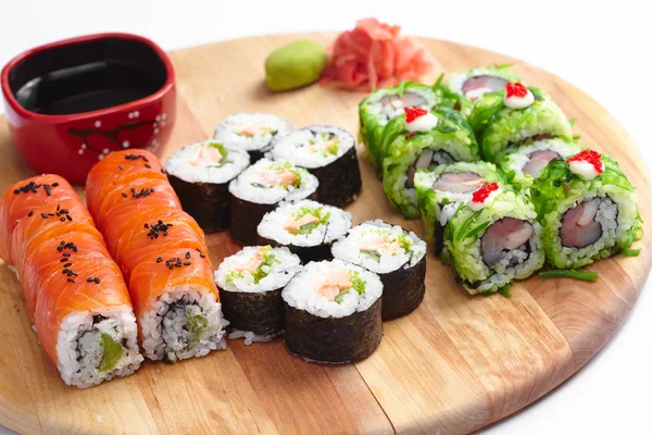 Rollos de sushi sobre tabla de madera — Foto de Stock