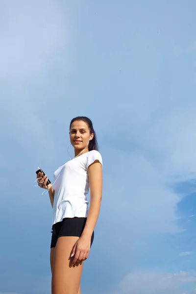 Woman runner with music player in hands — Stock Photo, Image