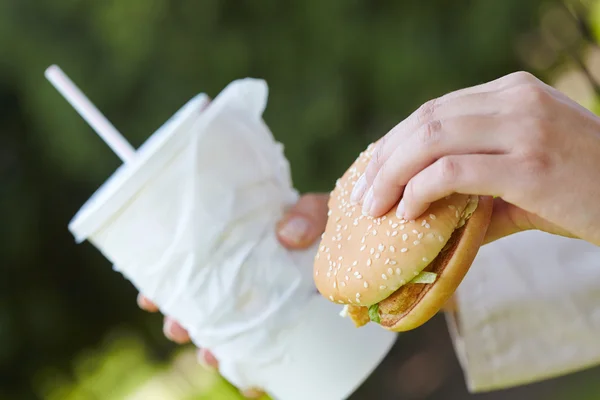 Mujer comiendo hamburguesa y cóctel —  Fotos de Stock