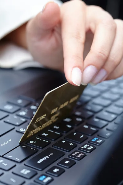 Frau hält Kreditkarte auf Laptop — Stockfoto
