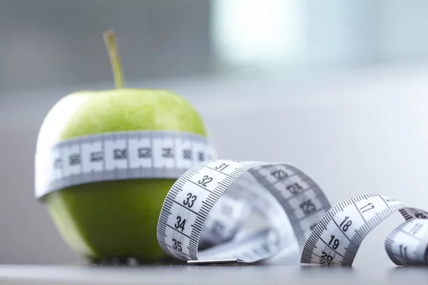 Green apples and measuring tape — Stock Photo, Image