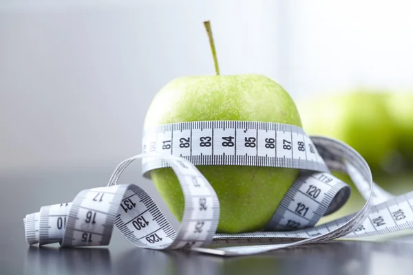 Green apples and measuring tape — Stock Photo, Image