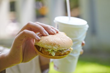 Hamburger ve kokteyl yemek kadın