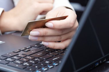 kredi kartı laptop üzerinde tutan kadın