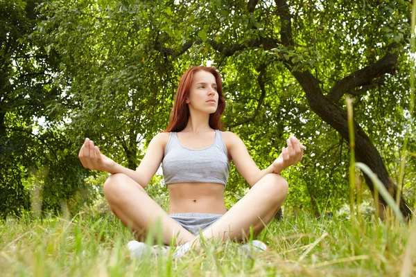 Woman doing yoga exercises in the park — Stock Photo, Image