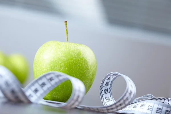 Green apples and measuring tape — Stock Photo, Image