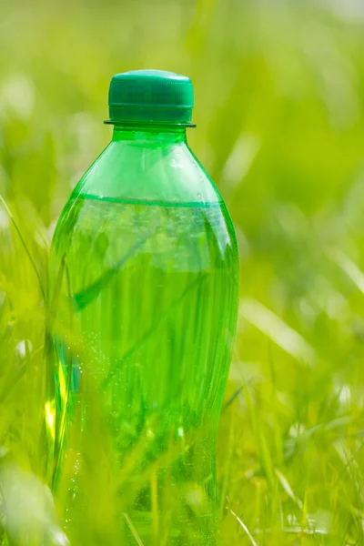 Butelka wody w trawie — Zdjęcie stockowe
