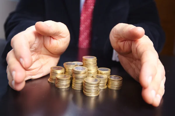 Businessman with stacks of coins — Stock Photo, Image