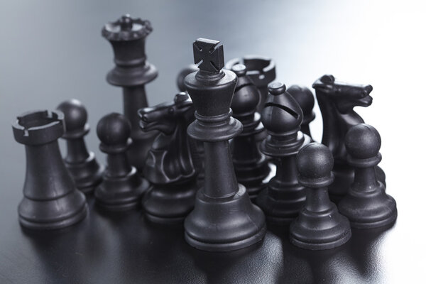 Black chess figures on dark background