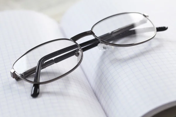 Composição com óculos e livro de notas — Fotografia de Stock