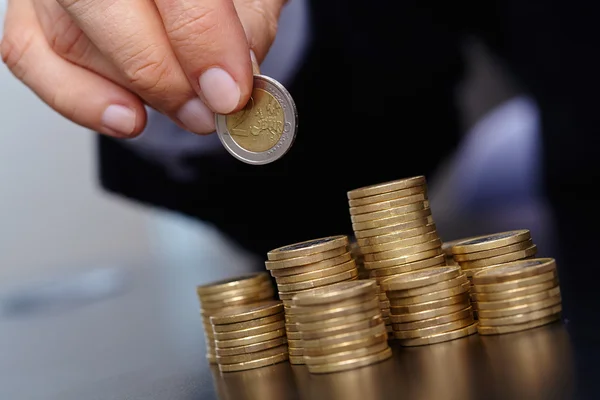 Businessman with stacks of coins — Stock Photo, Image