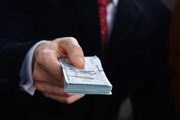 Billetes de tenencia de hombres de negocios — Foto de Stock