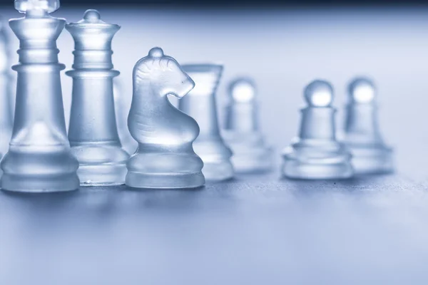 Стеклянные шахматы на сером — стоковое фото