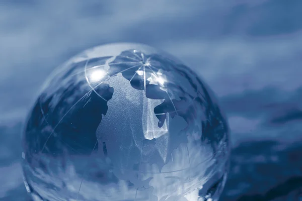 Glass globe on blue — Stock Photo, Image