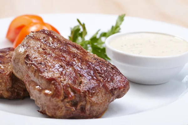 Tasty steaks with sauce — Stock Photo, Image