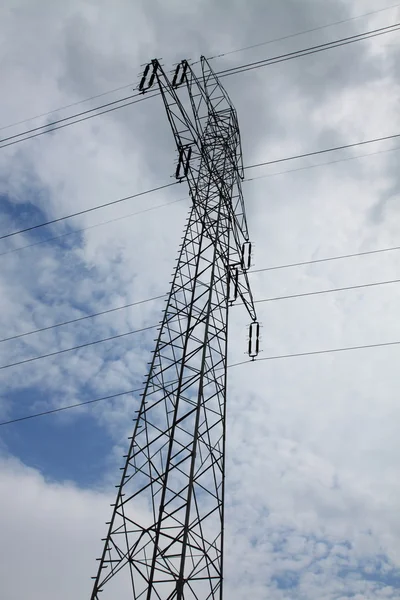 Høyspent mast under skyer – stockfoto