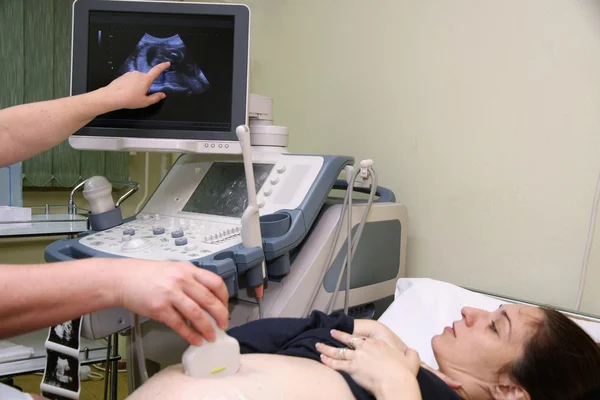 Gravid kvinna och läkare handens med ultraljud utrustning durin — Stockfoto