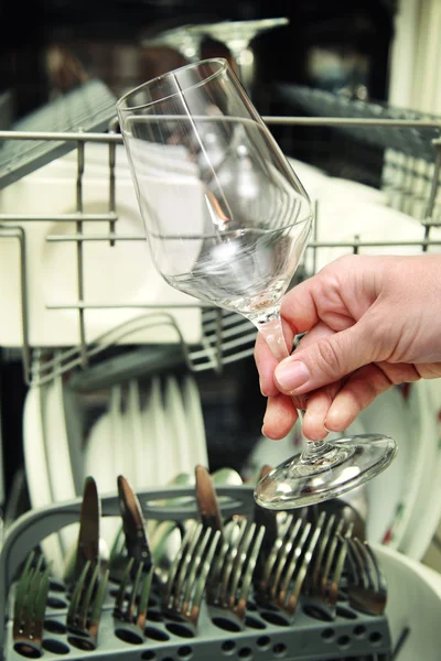 Kitchen Woman with a clean wine glass on background dishwasher — Stock Photo, Image