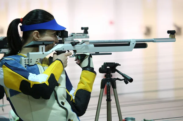 Woman aiming a pneumatic air rifle — Stock Photo, Image