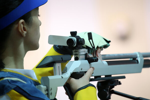 woman aiming a pneumatic air rifle