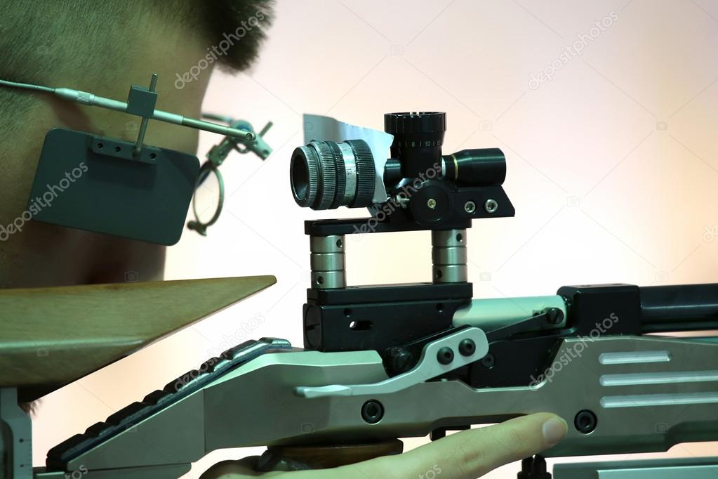 young man aiming a pneumatic air rifle