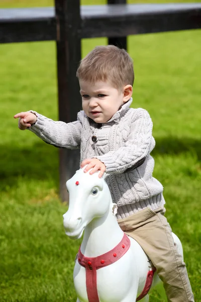 2 anos de idade menino brincando com cavalo — Fotografia de Stock