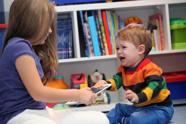 Chica y su hermano pequeño llorando y discutiendo con una ta digital — Foto de Stock