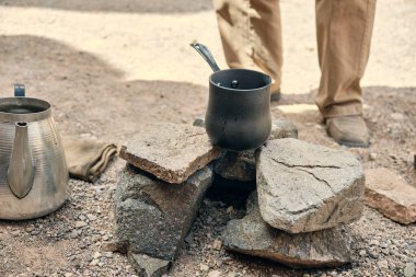 Şenlik ateşinde sıcak kahveyle metal cezalar. Yakın çekim.